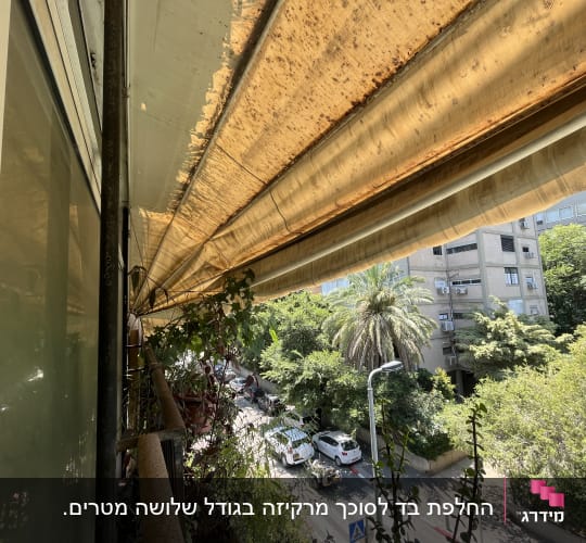 סוכך חום עם סימני בלאי מעל מרפסת